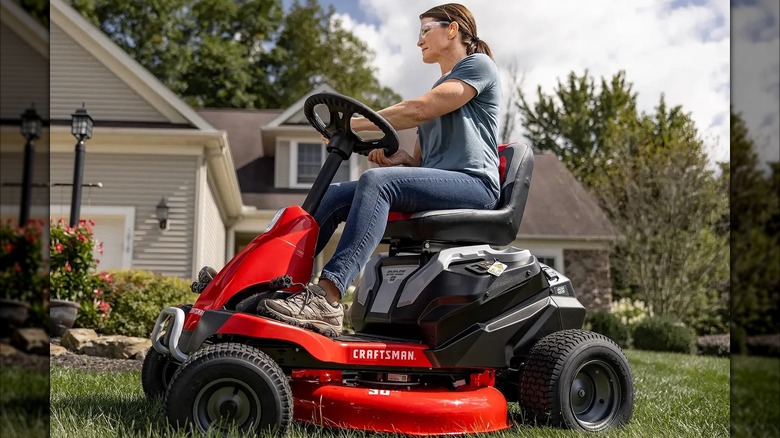 A Craftsman 56V MAX electric riding mower cutting grass side view