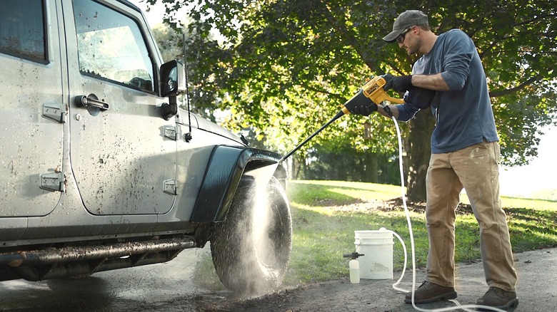 Person using DeWalt Pressure Washer on a Jeep