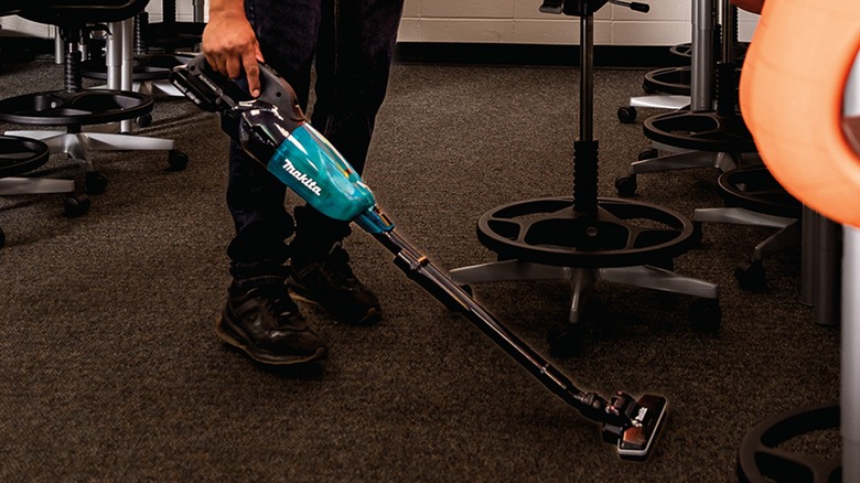 Person using Makita stick vacuum