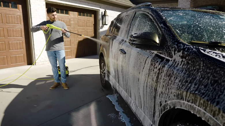 man using Ryobi 40V HP Brushless 1200 PSI 1.0 GPM Pressure Washer to clean car