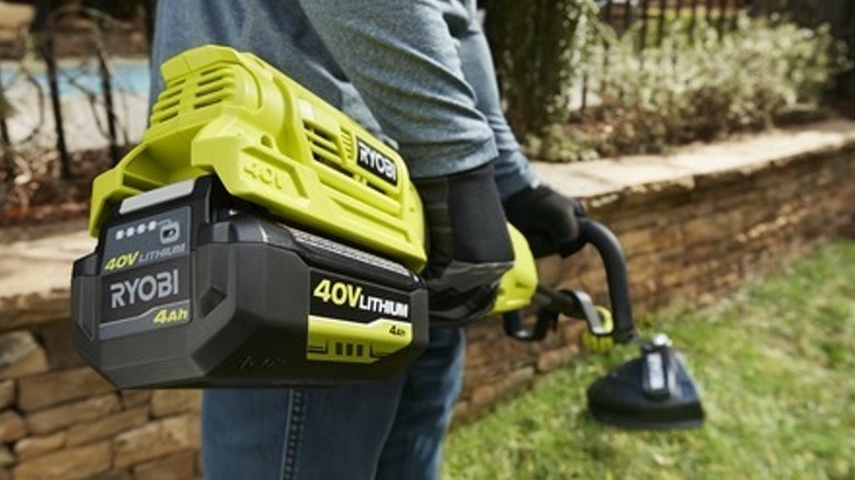 Person using Ryobi string trimmer