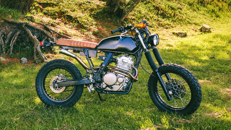 scrambler motorcycle parked on grass