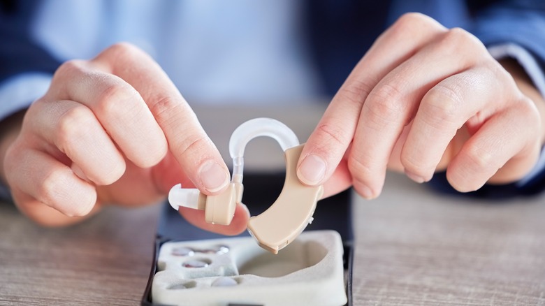 person holding hearing aids