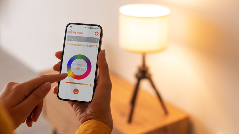 Hands controlling the color of a smart bulb through a smartphone app