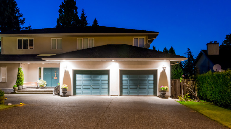 House with front driveway lit by external lights