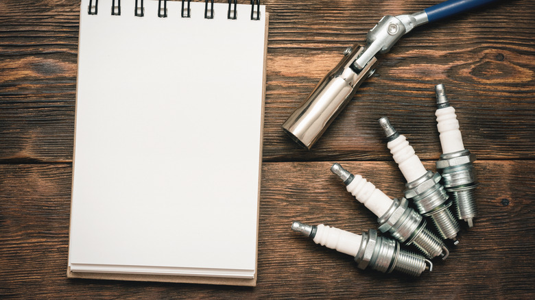 spark plugs and notepad on workbench