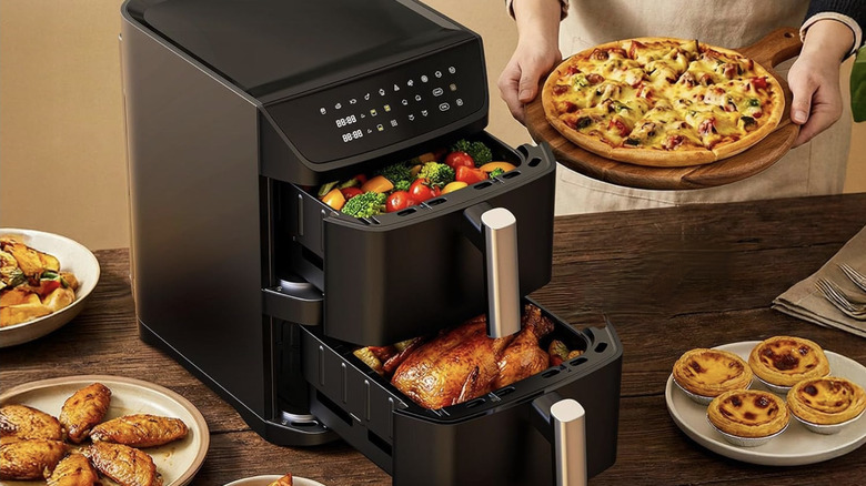 Veggies and chicken fill Mirtan Air Fryer while person holds pie nearby