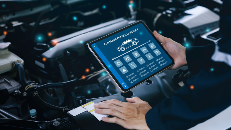 An Automotive Technician Using A Tablet Application For Vehicle Maintenance
