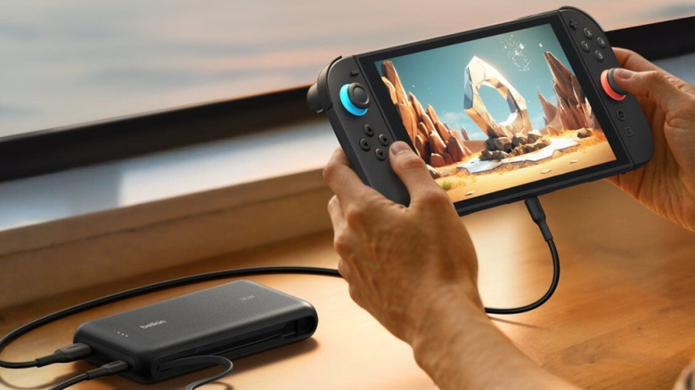 A person playing Nintendo Switch 2 while connected to Belkin power bank