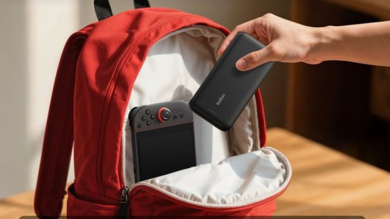 A person putting power bank inside backpack with Nintendo Switch 2