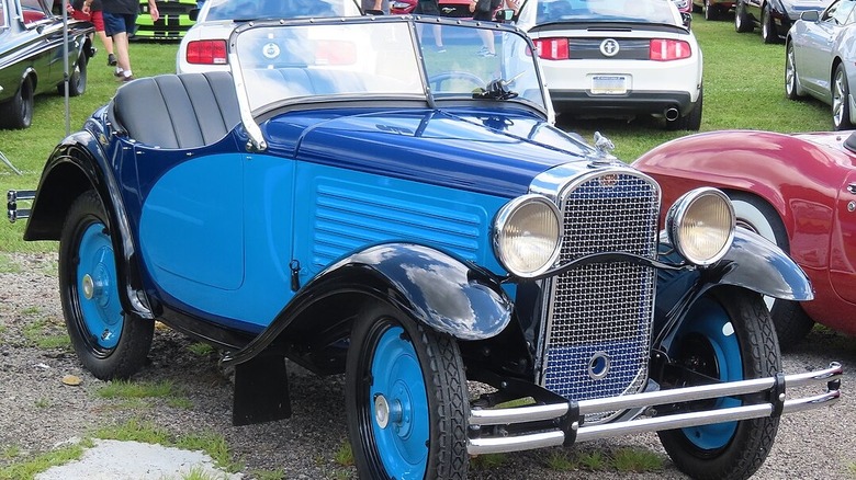 A blue 1931 American Austin at a car show