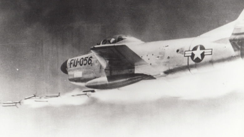 Black and white photo of an F-86D Sabre firing a barrage of Mighty Mouse rockets