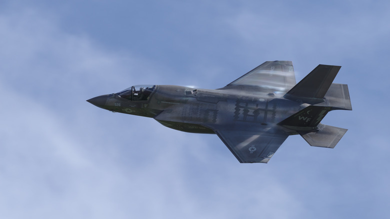 An F-35 Lightning II flying against an overcast sky