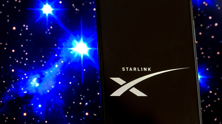Illustration showing a Starlink logo on a phone, against a space background