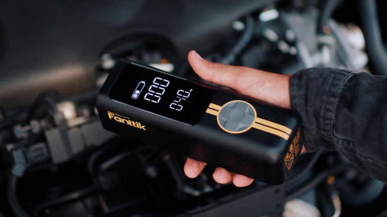 Person holding a Fanttik X8 APEX Tire Inflator Portable Air Compressor.