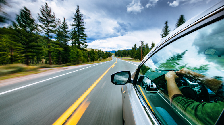 Side view of car driving on road.