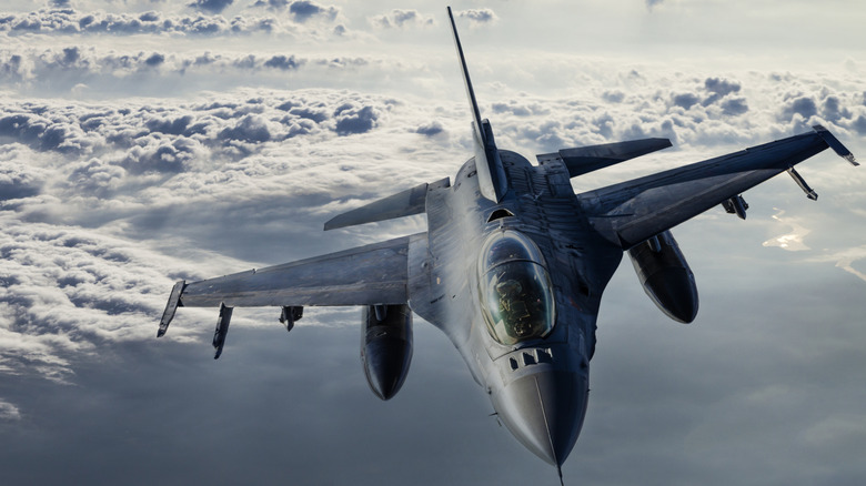 Jet fighter flying above clouds