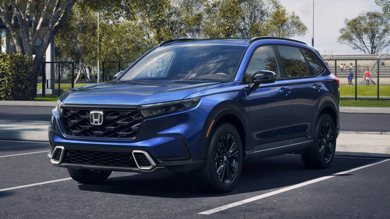 Blue 2026 Honda CR-V Sport Touring Hybrid SUV in a parking lot.