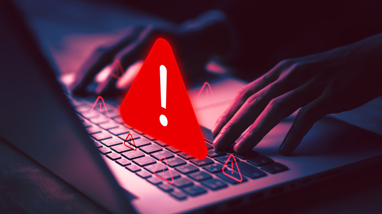 A red warning sign above a laptop keyboard.