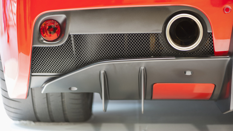 A close-up of a Ferrari 488 exhaust system mounted above the rear diffuser.