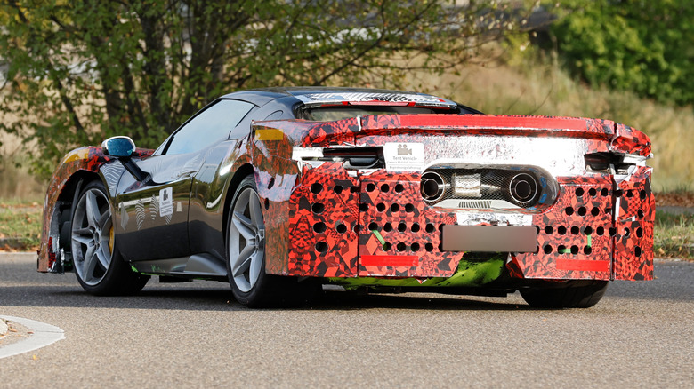 A rear three-quarter view of a camouflaged reported Ferrari 296 Challenge Stradale