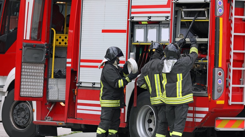 Fire fighters unloading gear from a fire truck