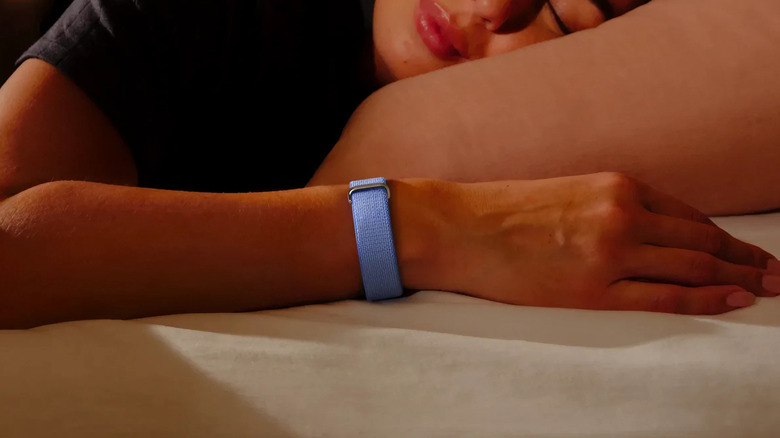 A woman wearing the Fitbit Air in purple