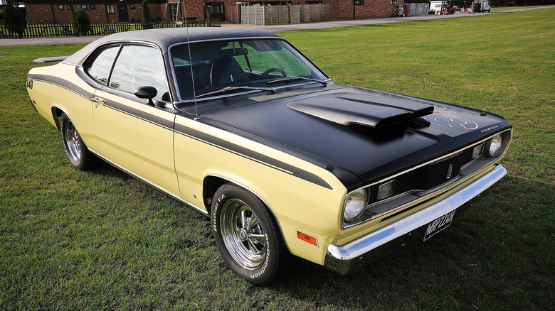 A two-tone 1970 Plymouth Duster 340 parked on a lawn.