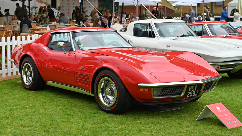 A red 1970s Corvette C3 parked on a lawn on display.