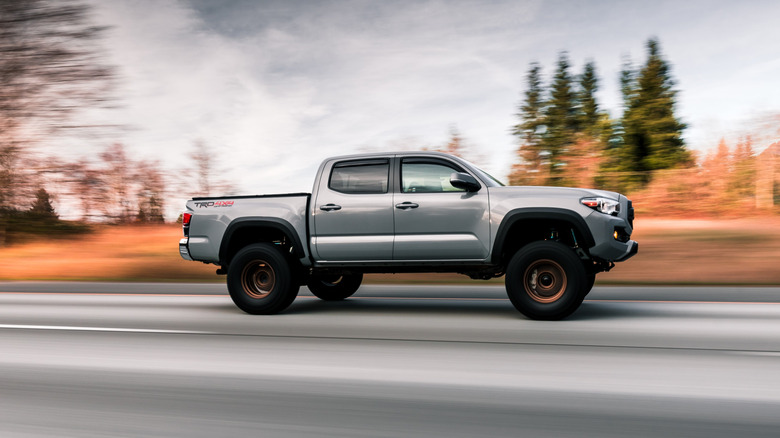 A 2017 Toyota Tacoma being driven with trees blurred in the background.