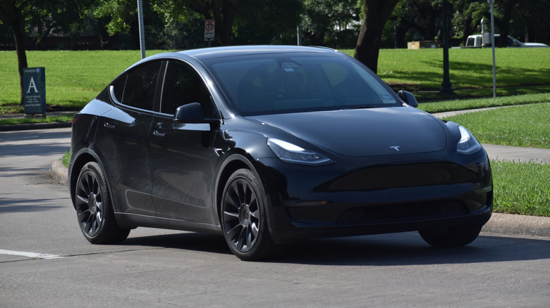 A blacked out Tesla Model X EV SUV driven on a public road.