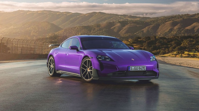 A purple Porsche Taycan Turbo GT parked on the Laguna Seca racetrack.