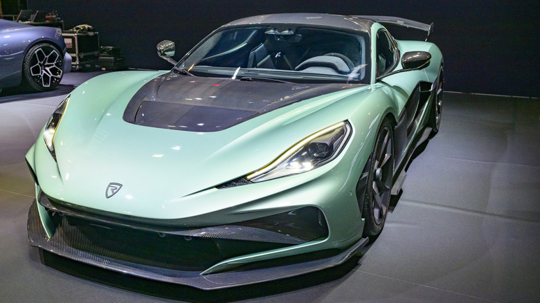 A light green Rimac Nevera R parked on a Rimac indoor display.