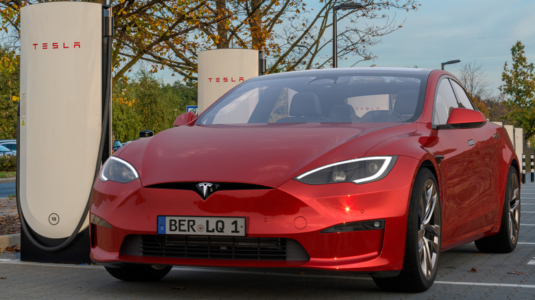A red Tesla Model S Plaid being charged on a Tesla Supercharger in Germany.