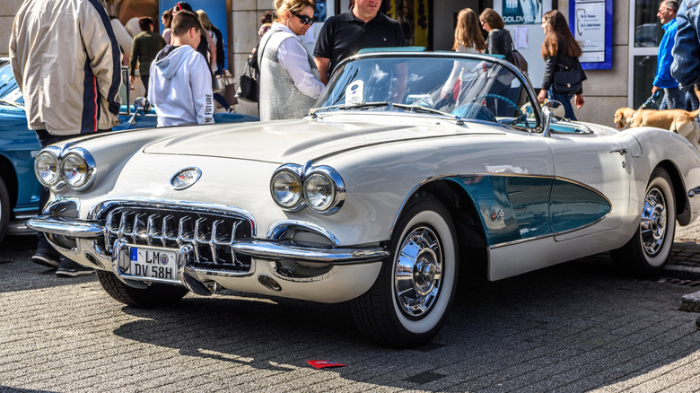 A three-quarter view of a white and blue Chevrolet C1 Corvette convertible parked on display.