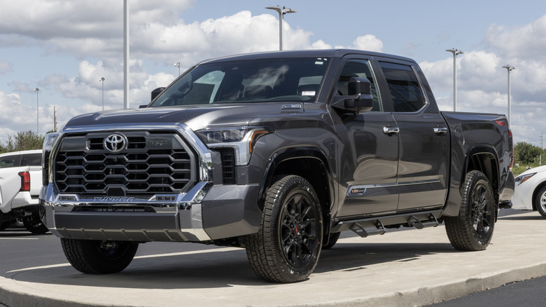 A gray CrewMax Toyota Tundra parked outside with other cars in the background.