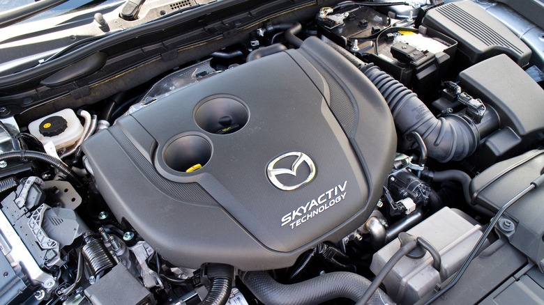 A top-down view of a Mazda Skyactiv engine cover in a car.