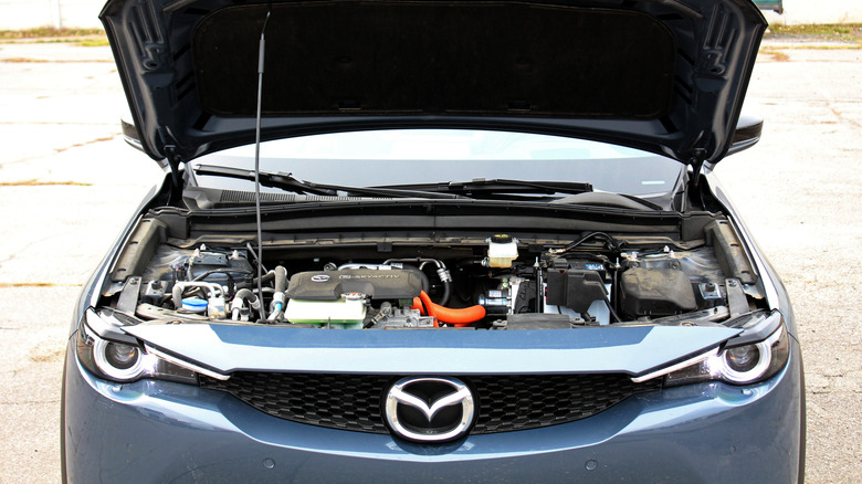 A front-end view of a Mazda SUV with the hood open.
