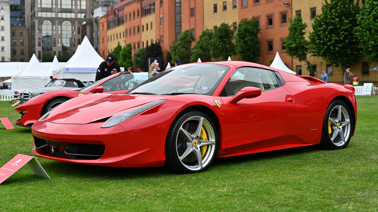 A red Ferrari 458 Spyder parked on grass display.