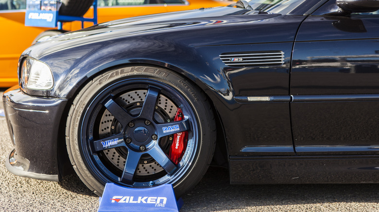 A front-end side view of a highly modified dark blue BMW E46 M3 wearing Falken tires.