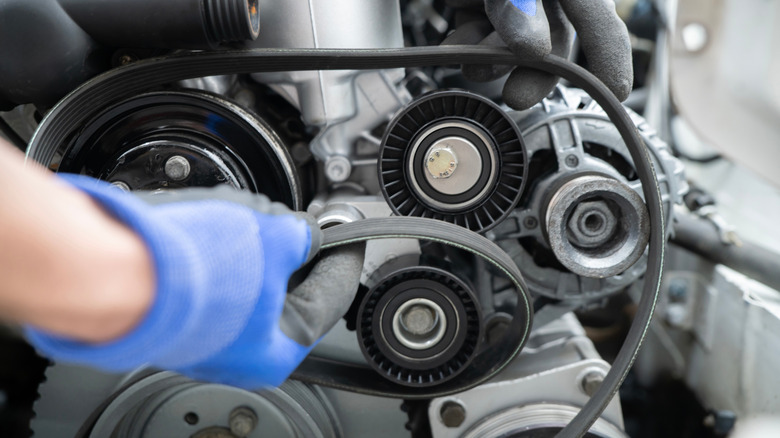 Close-up of a mechanic working on a timing belt replacement.