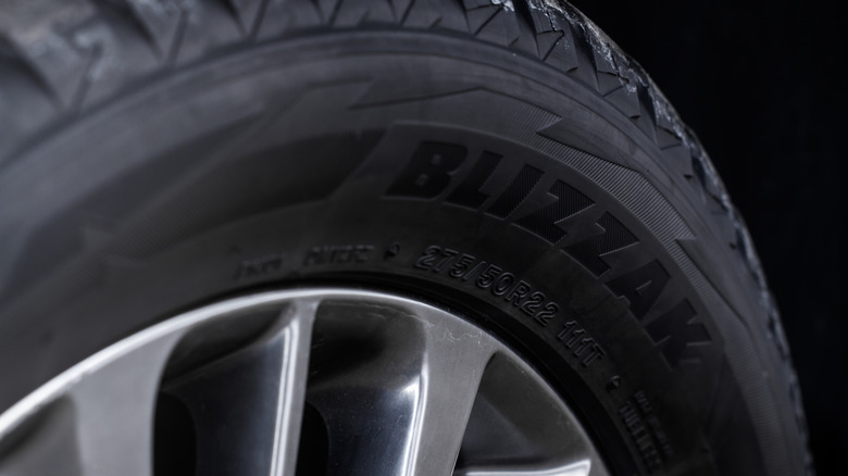 A close-up of a Bridgestone Blizzak winter tire mounted on a wheel.