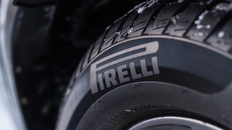 A close-up of a Pirelli tire mounted on a wheel with snow on it.