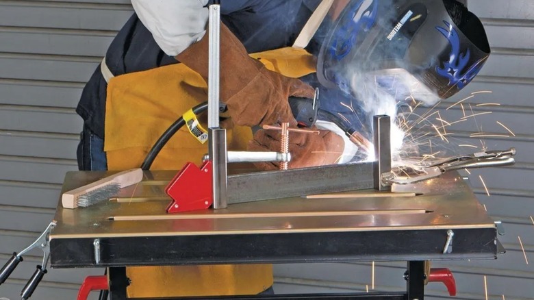 A person using a Chicago Electric welding table.