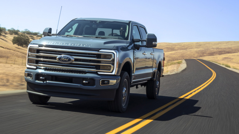 2023 Ford Super Duty truck driving on rural road