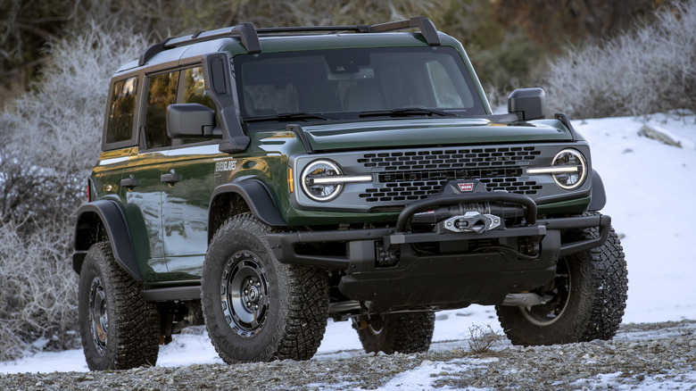A dark green Ford Bronco Everglades parked off-road in the snow