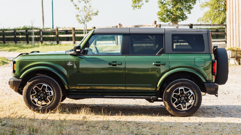 A side profile view of a green Ford Bronco parked in sunny outdoors