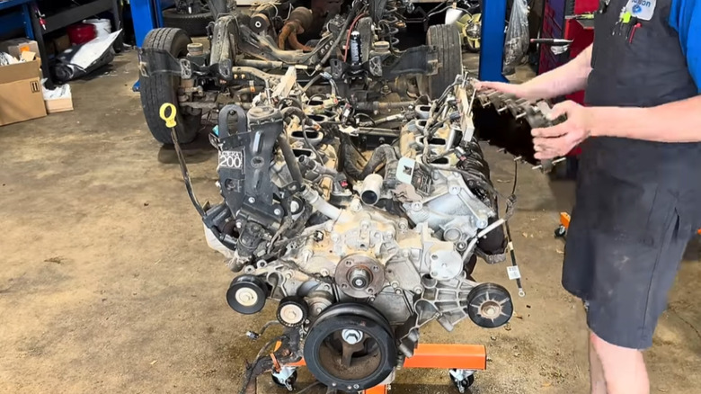 mechanic removing valve cover from Ford Godzilla V8