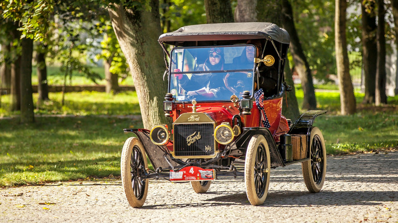Red Ford Model T with parade bunting on cobbled road