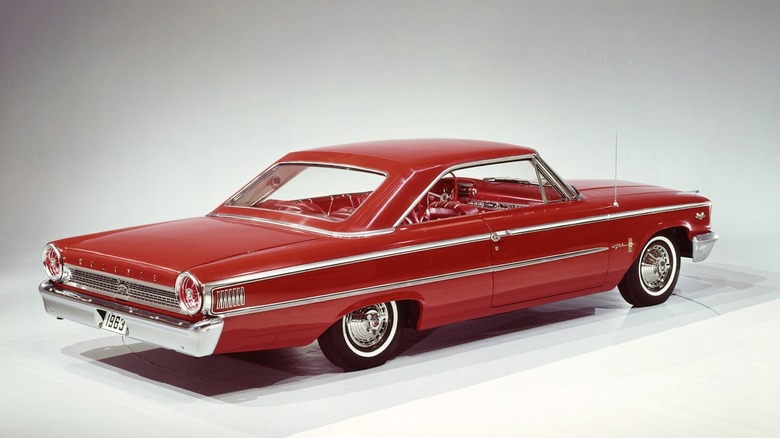 Right rear 3/4 view of a red 1963 Ford Galaxie against a white studio background